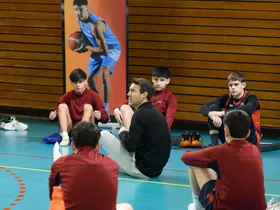 Entrenamiento preventivo grupal con jugadores de básquet en el gimnasio