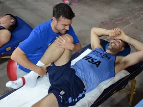 Terapia manual a un jugador de la Selección Argentina de Básquet en camilla
